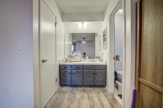 bathroom featuring vanity, toilet, and a textured ceiling