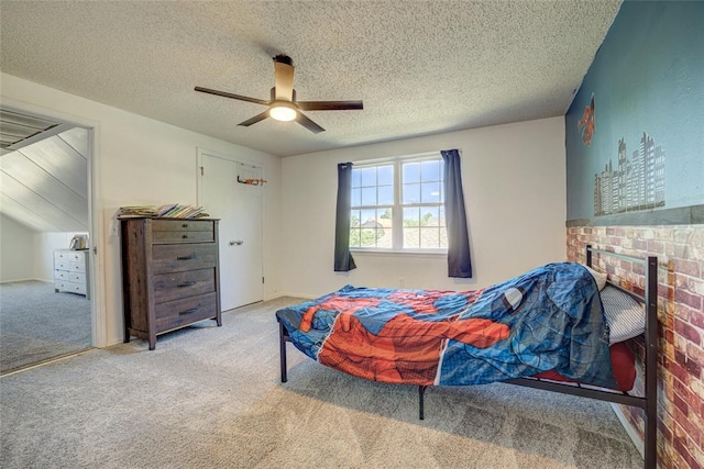 bedroom with ceiling fan, carpet, a brick fireplace, and a textured ceiling