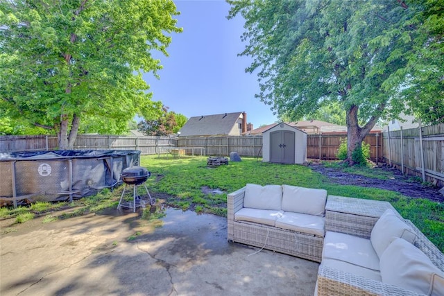 view of yard with a storage unit, a fenced backyard, outdoor lounge area, and a patio area