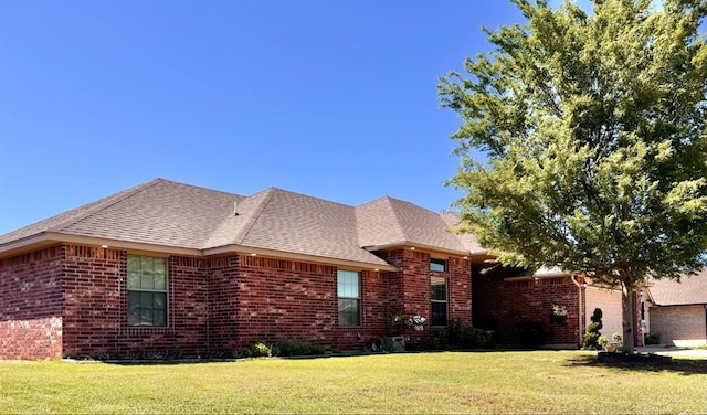 ranch-style house with brick siding, a garage, and a front yard