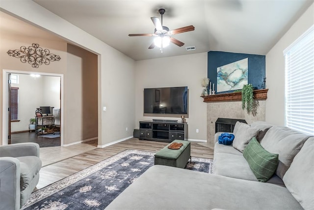 living area with plenty of natural light, ceiling fan, vaulted ceiling, and wood finished floors