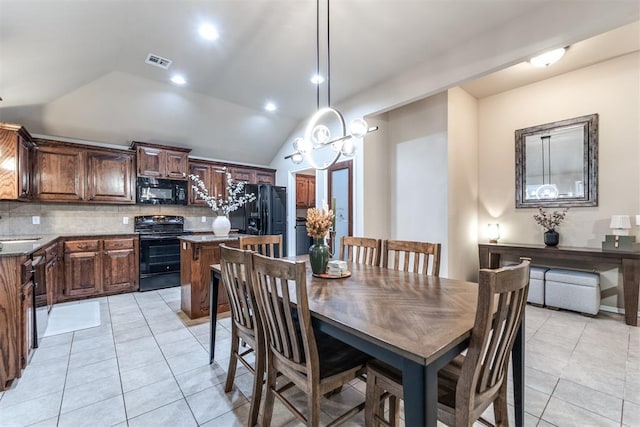 dining room featuring lofted ceiling, light tile patterned flooring, and visible vents
