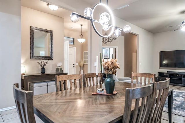 dining area with ceiling fan, baseboards, and tile patterned flooring
