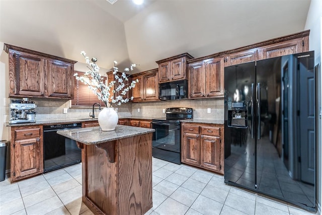 kitchen with a sink, tasteful backsplash, black appliances, and light tile patterned flooring