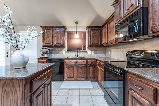 kitchen with a sink, dark stone counters, decorative backsplash, and black appliances