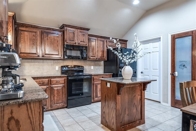 kitchen featuring light tile patterned flooring, backsplash, vaulted ceiling, a kitchen island, and black appliances