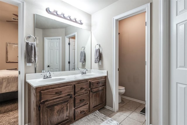 bathroom featuring a sink, double vanity, toilet, tile patterned floors, and ensuite bathroom