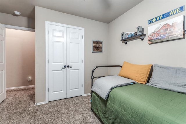 bedroom with baseboards, light colored carpet, and a closet