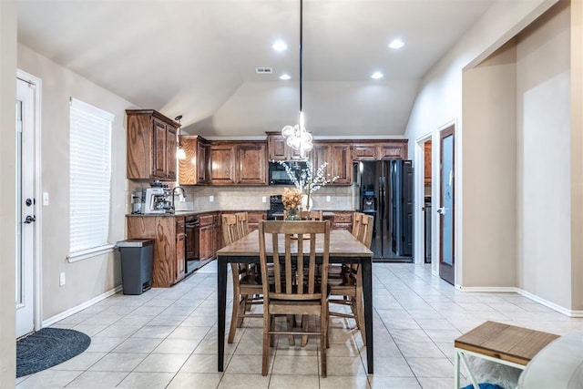 kitchen featuring vaulted ceiling, decorative backsplash, light tile patterned floors, and black appliances