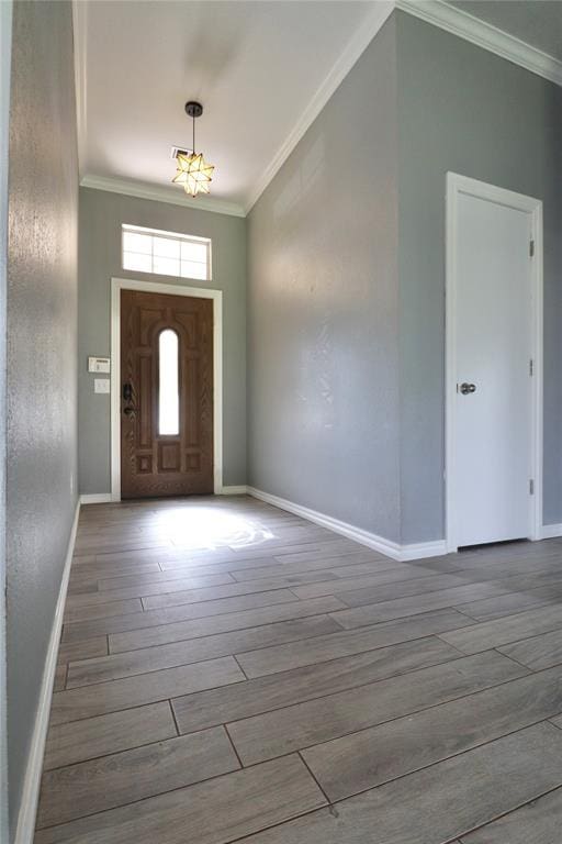 entryway with crown molding, baseboards, and wood finished floors