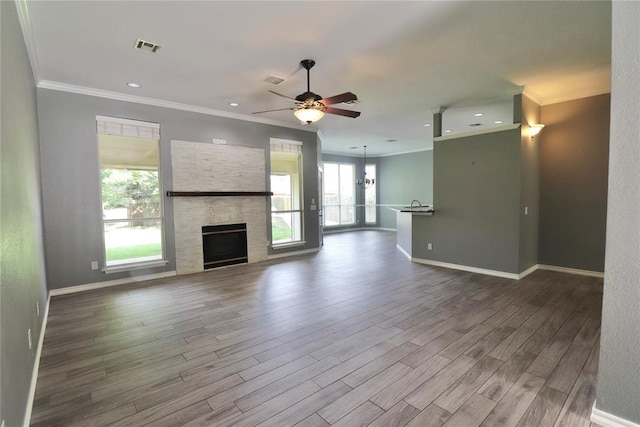 unfurnished living room featuring visible vents, a ceiling fan, dark wood-style flooring, and ornamental molding