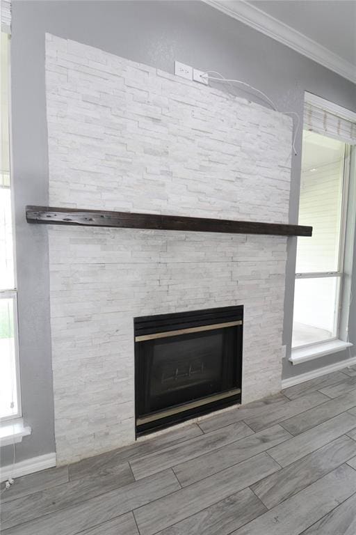 details with crown molding, baseboards, a fireplace, and wood finished floors