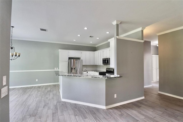 kitchen with light wood-type flooring, ornamental molding, appliances with stainless steel finishes, and light stone countertops