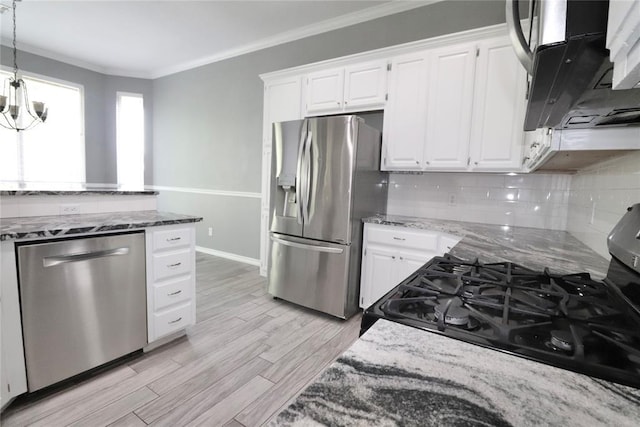 kitchen featuring appliances with stainless steel finishes, ornamental molding, and light stone counters