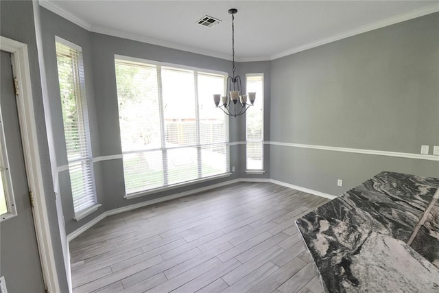 unfurnished dining area featuring an inviting chandelier, crown molding, visible vents, wood finished floors, and baseboards