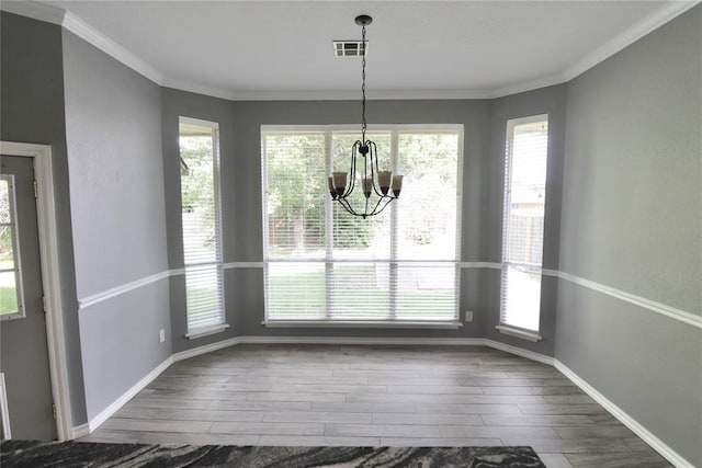 unfurnished dining area featuring baseboards, a wealth of natural light, wood finished floors, and a chandelier