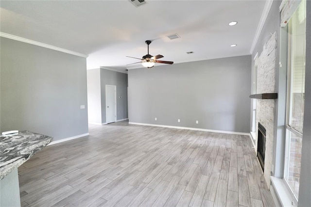 unfurnished living room with ceiling fan, a fireplace, light wood-style floors, visible vents, and ornamental molding