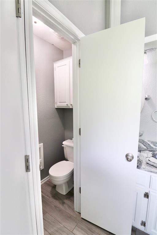 bathroom featuring toilet and wood finished floors
