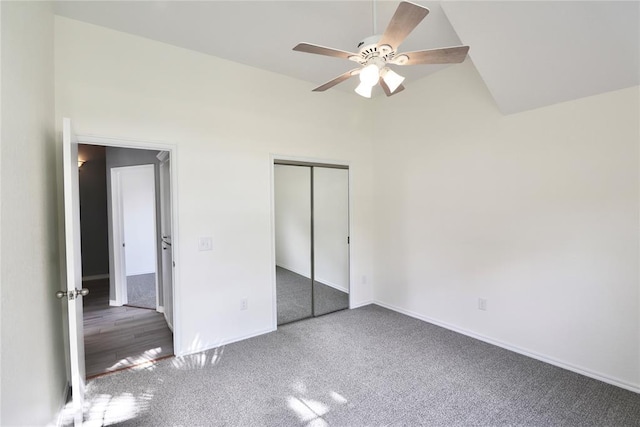 unfurnished bedroom featuring vaulted ceiling, baseboards, carpet, and a closet
