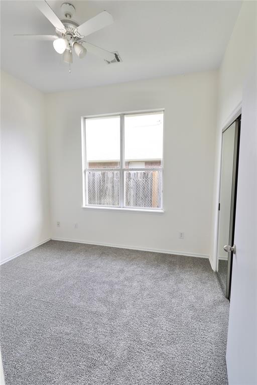unfurnished room with visible vents, carpet, ceiling fan, and baseboards