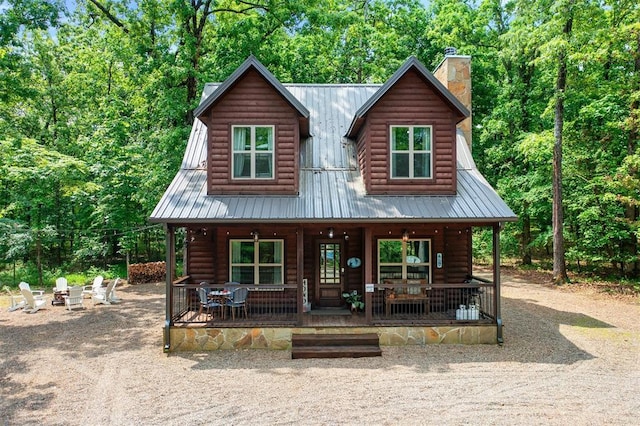 678 N State Highway 259a, Broken Bow, OK 74728 - view of front of home with covered porch, a chimney, an outdoor fire pit, and metal roof