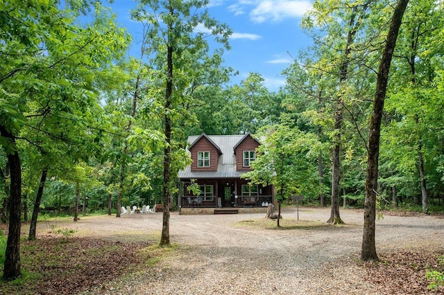 678 N State Highway 259a, Broken Bow, OK 74728 - view of front of property featuring a view of trees, a porch, metal roof, and curved driveway