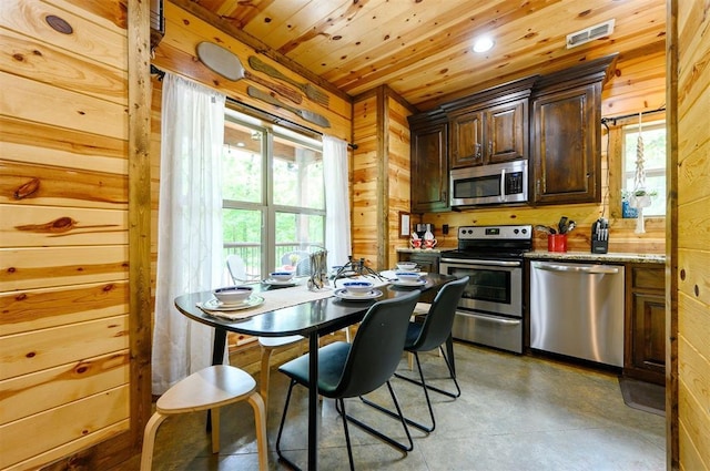 678 N State Highway 259a, Broken Bow, OK 74728 - kitchen featuring dark brown cabinetry, wooden walls, wooden ceiling, concrete floors, and appliances with stainless steel finishes