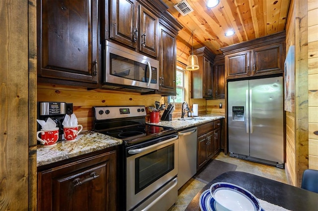 678 N State Highway 259a, Broken Bow, OK 74728 - kitchen with a sink, dark brown cabinetry, stainless steel appliances, and wood walls