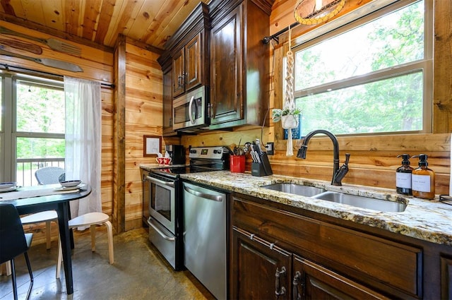 678 N State Highway 259a, Broken Bow, OK 74728 - kitchen featuring stainless steel appliances, wood walls, a wealth of natural light, and a sink