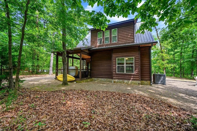 678 N State Highway 259a, Broken Bow, OK 74728 - back of property featuring faux log siding, cooling unit, and metal roof