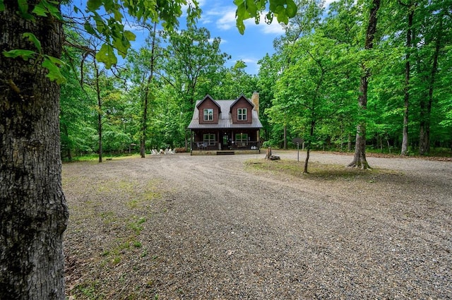 678 N State Highway 259a, Broken Bow, OK 74728 - rustic home with covered porch, curved driveway, a chimney, and metal roof