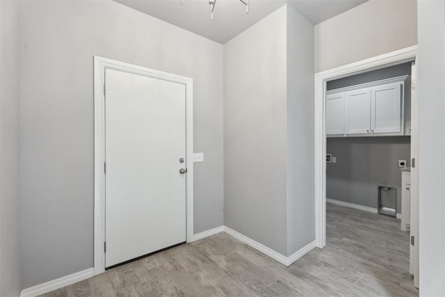 foyer entrance with baseboards and light wood-style flooring