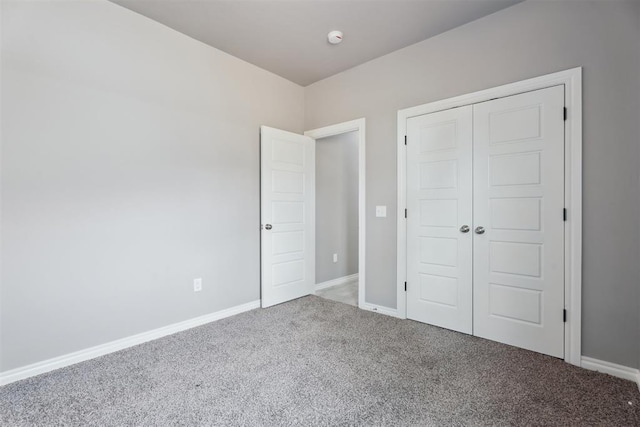 unfurnished bedroom featuring carpet floors, baseboards, and a closet