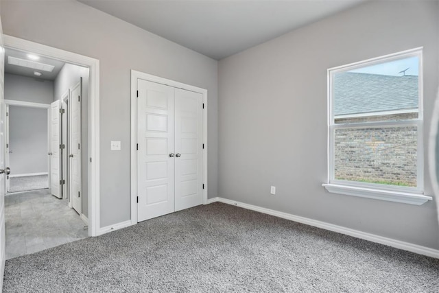 unfurnished bedroom with baseboards, carpet, and a closet
