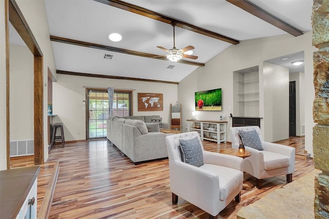 living room featuring lofted ceiling with beams, light wood finished floors, built in shelves, a ceiling fan, and visible vents