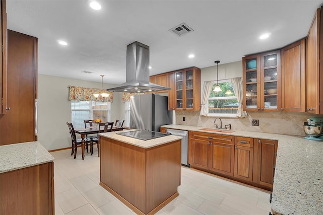 kitchen featuring brown cabinetry, visible vents, island range hood, a sink, and stainless steel appliances