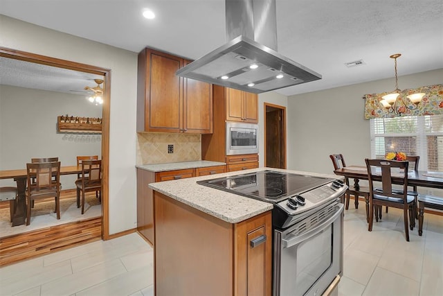 kitchen featuring decorative backsplash, visible vents, island range hood, brown cabinets, and stainless steel appliances
