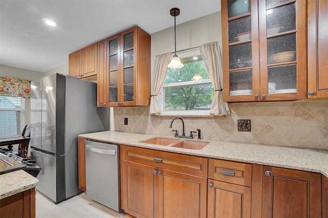 kitchen featuring a sink, pendant lighting, brown cabinetry, and stainless steel appliances