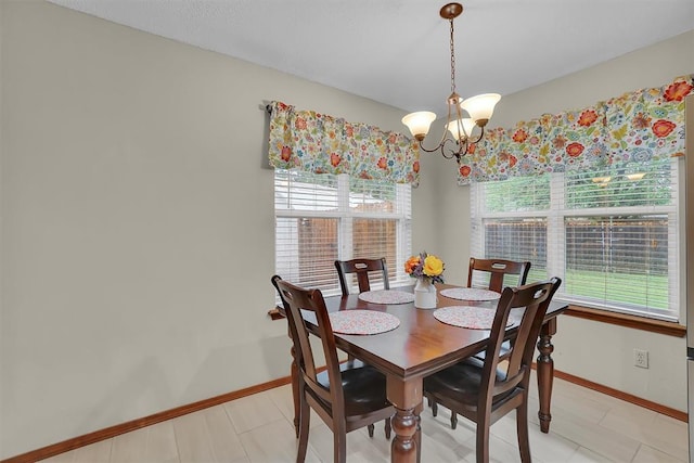 dining room with baseboards and a notable chandelier