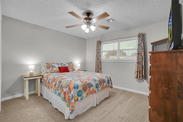 carpeted bedroom featuring baseboards, a textured ceiling, and visible vents
