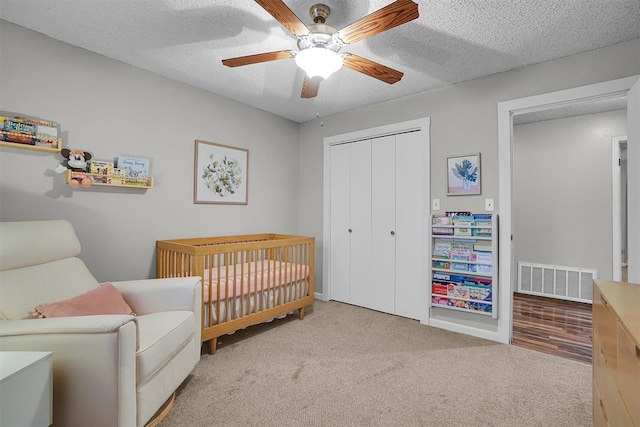 carpeted bedroom with visible vents, baseboards, ceiling fan, and a closet