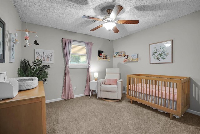 bedroom with carpet flooring, a ceiling fan, baseboards, and a crib