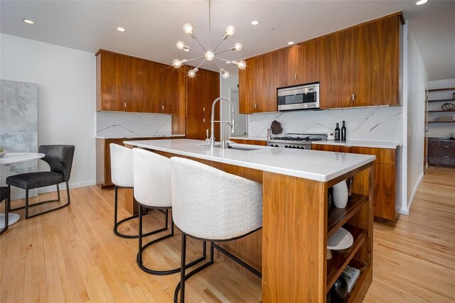 1000 NW 37th St Unit 1000 & 1002, Oklahoma City, OK 73118 - kitchen with brown cabinetry, a sink, light countertops, stainless steel microwave, and light wood finished floors