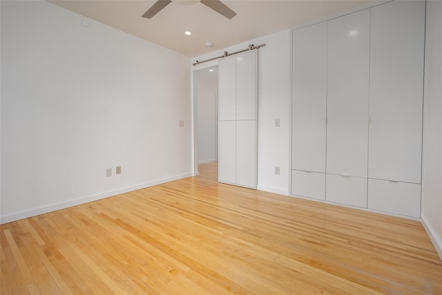 1000 NW 37th St Unit 1000 & 1002, Oklahoma City, OK 73118 - unfurnished bedroom featuring a barn door, light wood-style floors, a ceiling fan, baseboards, and recessed lighting