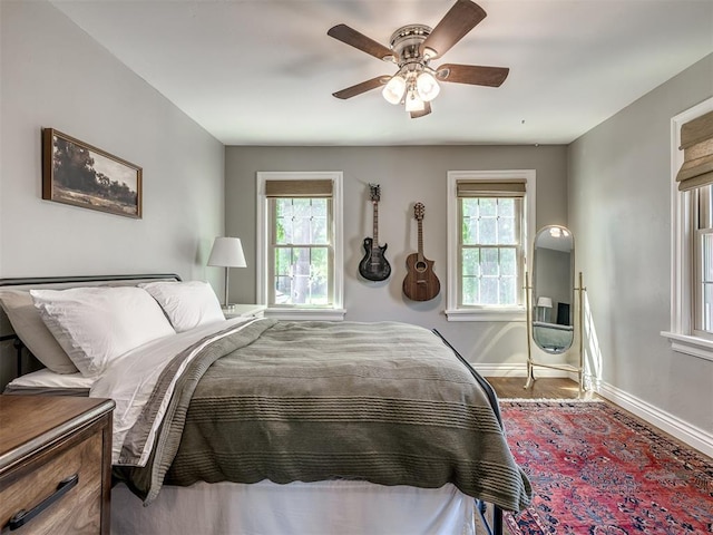 bedroom featuring baseboards, ceiling fan, and wood finished floors