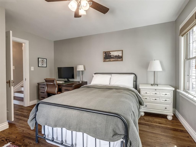 bedroom featuring baseboards, multiple windows, a ceiling fan, and dark wood finished floors