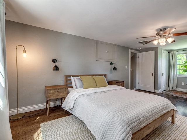 bedroom featuring a ceiling fan, baseboards, and wood finished floors