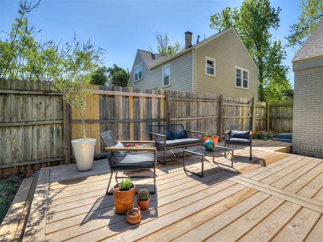 wooden terrace featuring outdoor lounge area and a fenced backyard