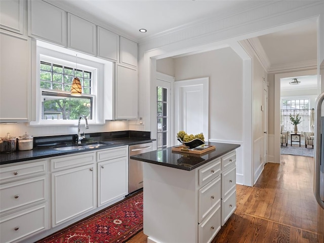 kitchen featuring crown molding, dark wood-style floors, plenty of natural light, a sink, and dishwasher