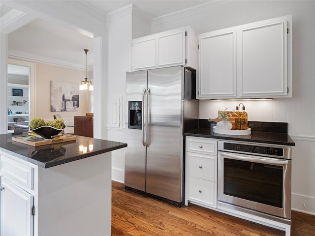 kitchen featuring ornamental molding, wood finished floors, white cabinetry, appliances with stainless steel finishes, and a notable chandelier